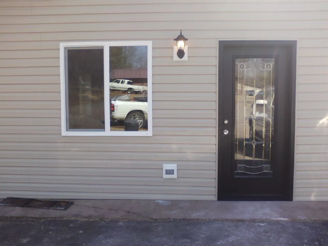 New siding, window and entry door on the side of an addition in Nassau