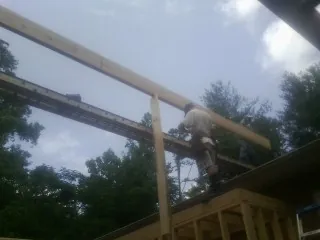Carpenter setting a ridge beam over a new addition frame — Ice Dam Removal by Roofing Brothers in Nassau