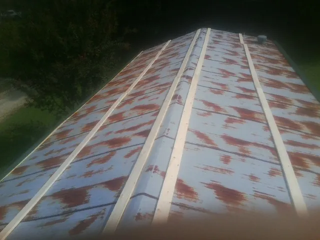Rusted metal roof panels with new wood purlins before replacement — Storm Damage Roof Repair in Nassau by Roofing Brothers